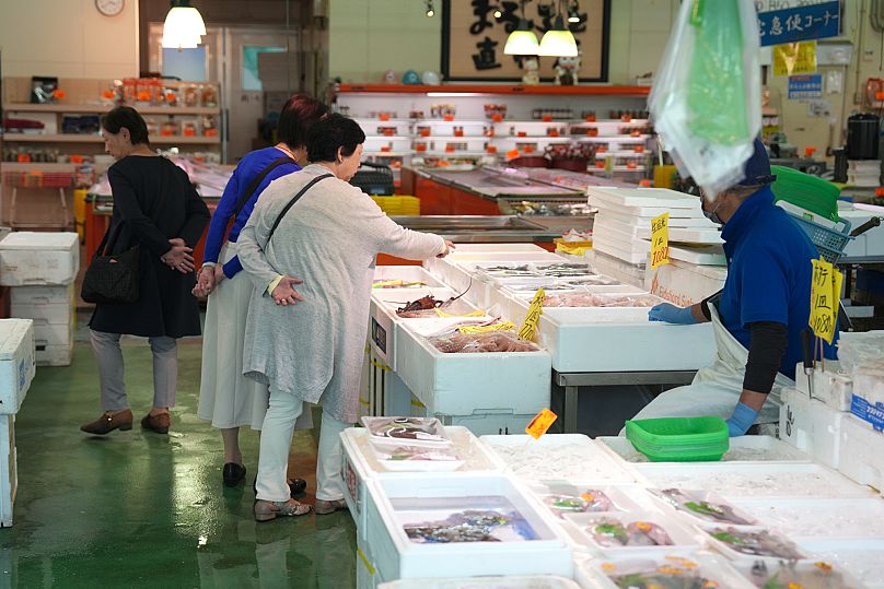 Visitors check seafood sold at the seafood market near the Onahama fish port in Iwaki City, 19 October, 2023 